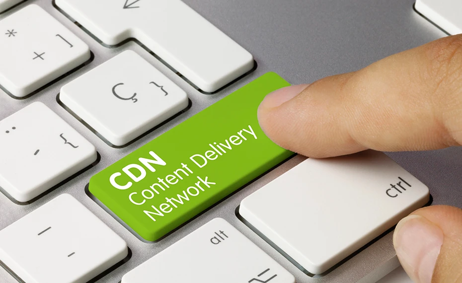 Finger pressing a blue metallic keyboard key labelled cdn content delivery network