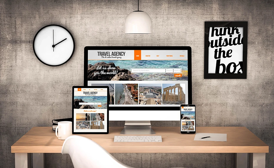 Modern office workspace of a travel agency with digital devices displaying a professional website for online bookings and client management.
